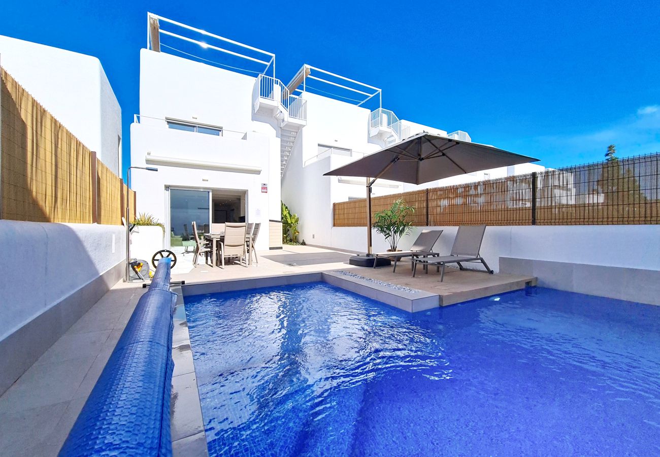 Villa moderne de 3 chambres à Los Alcázares avec piscine privée en forme de L et chaises longues.